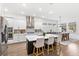 Modern kitchen with white cabinetry, stainless steel appliances, large island and adjacent dining area at 15343 Lebeau Loop, Winter Garden, FL 34787