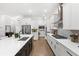Spacious kitchen featuring white cabinetry, a large island, stainless steel appliances and hardwood floors at 15343 Lebeau Loop, Winter Garden, FL 34787