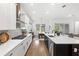 Open kitchen layout with a black island, quartz countertops, and seamless flow into the living area at 15343 Lebeau Loop, Winter Garden, FL 34787