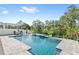 Relaxing backyard pool with waterfall feature, patio seating, manicured landscaping, and privacy fence at 15343 Lebeau Loop, Winter Garden, FL 34787