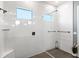 Modern shower with white tile, glass partition, and dual shower heads at 15343 Lebeau Loop, Winter Garden, FL 34787