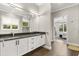Bathroom with double vanity, white cabinets, and black countertop leading to the main bedroom at 1541 Chestnut Ave, Winter Park, FL 32789