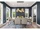 Dining room features modern lighting fixture, dark walls, and light-colored wood table and chairs at 1541 Chestnut Ave, Winter Park, FL 32789
