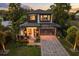 A modern two-story home is adorned with elegant lighting, brick driveway, and professional landscaping at 1541 Chestnut Ave, Winter Park, FL 32789