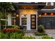 Charming front entrance with a modern door, stylish lighting, and lush landscaping at 1541 Chestnut Ave, Winter Park, FL 32789