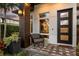 Inviting front porch with a modern door, stylish seating, and beautiful greenery at 1541 Chestnut Ave, Winter Park, FL 32789