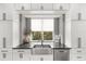 Bright kitchen featuring a stainless steel sink, modern faucet, and white cabinets at 1541 Chestnut Ave, Winter Park, FL 32789