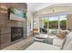 Modern living room with a cozy fireplace, comfortable seating, and large sliding doors with a pool view at 1541 Chestnut Ave, Winter Park, FL 32789