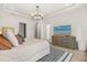 Spacious bedroom featuring a tray ceiling, modern lighting fixture and a stylish dresser at 1541 Chestnut Ave, Winter Park, FL 32789