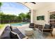 Inviting covered patio with comfortable seating, a TV, and a view of the pool at 1541 Chestnut Ave, Winter Park, FL 32789