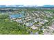 Panoramic aerial of residential area featuring lake, green spaces, and tiled roofs at 157 Bell Tower E Xing, Kissimmee, FL 34759
