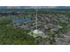 Aerial view showcases home with its manicured lawn, lush landscaping, and proximity to a scenic lake at 157 Bell Tower E Xing, Kissimmee, FL 34759