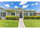 Charming home with a well-manicured lawn, walkway, and inviting covered porch with stately columns at 157 Bell Tower E Xing, Kissimmee, FL 34759