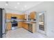 Well-lit kitchen with stainless appliances, wood cabinets, tile floors and backyard access at 157 Bell Tower E Xing, Kissimmee, FL 34759