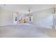 Bright living room featuring neutral carpet, an arched doorway, and multiple sunny windows at 157 Bell Tower E Xing, Kissimmee, FL 34759