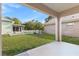 Inviting backyard with a covered patio, lush green lawn, and white picket fence for added charm at 16602 Citrus Pkwy, Clermont, FL 34714