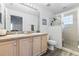 Bathroom featuring double sinks, a walk-in shower with glass block window, and ample storage space at 16602 Citrus Pkwy, Clermont, FL 34714