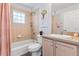 Clean bathroom with a tub/shower combination, neutral tile, and classic vanity with ample lighting at 16602 Citrus Pkwy, Clermont, FL 34714