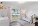 Bright Bedroom with soft pink accents, a crib, and views of the front yard through the window at 16602 Citrus Pkwy, Clermont, FL 34714