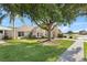 A single-story home with beautiful lawn and landscaping, plus a covered carport area and mature shade tree at 16602 Citrus Pkwy, Clermont, FL 34714