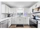 Well-lit kitchen with white cabinets, modern appliances and hardwood flooring, perfect for cooking at 16602 Citrus Pkwy, Clermont, FL 34714