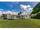Backyard showing the exterior of the home and the expansive lawn, enhanced by palm trees and clear skies at 1746 Valley Forge Road, Orlando, FL 32806