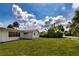 Spacious backyard with lush green lawn, palm trees, and the exterior of the home at 1746 Valley Forge Road, Orlando, FL 32806