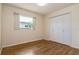 Bright bedroom featuring hardwood floors, a window for natural light, and a double-door closet for ample storage at 1746 Valley Forge Road, Orlando, FL 32806
