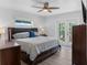 Bright bedroom features wood flooring, a ceiling fan, and a private entrance to the outdoor living space at 1850 Geronimo Trl, Maitland, FL 32751