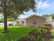 Well-maintained home exterior with lush green lawn, mature trees, and manicured landscaping at 1850 Geronimo Trl, Maitland, FL 32751