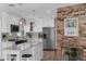Bright kitchen boasts stainless appliances, white cabinetry, and a brick accent wall at 1850 Geronimo Trl, Maitland, FL 32751