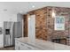 Updated kitchen featuring white cabinets, stainless appliances, and a brick accent wall at 1850 Geronimo Trl, Maitland, FL 32751