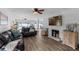 Spacious living room with wood-look flooring, a brick fireplace, and an open layout into the adjoining living area at 1850 Geronimo Trl, Maitland, FL 32751