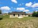 The home has a spacious backyard with green grass and a patio, perfect for outdoor activities at 1877 Courtland Blvd, Deltona, FL 32738