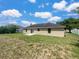 The backyard features an expanse of grass and a simple patio area, with ample space for outdoor activities at 1877 Courtland Blvd, Deltona, FL 32738