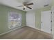 The bright bedroom offers neutral carpet, a ceiling fan, closet, and a window for natural light at 1877 Courtland Blvd, Deltona, FL 32738