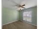 A minimalistic bedroom with neutral carpet, a ceiling fan, and window providing natural light at 1877 Courtland Blvd, Deltona, FL 32738