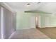 Neutral living room showcasing tile flooring, sliding glass doors, and access to bedrooms at 1877 Courtland Blvd, Deltona, FL 32738