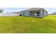 View of the home's backyard featuring lush green lawn and covered patio space at 200 Garnet Ave, Kissimmee, FL 34758