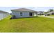 Lawn view of the backyard, showcasing the home's rear facade and covered patio at 200 Garnet Ave, Kissimmee, FL 34758
