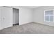 Neutral carpeted bedroom featuring a closet with sliding doors and a window at 200 Garnet Ave, Kissimmee, FL 34758