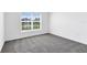 Neutral carpeted bedroom with bright window looking out to neighborhood at 200 Garnet Ave, Kissimmee, FL 34758