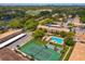Aerial view of complex showcasing pool, tennis courts, carports, and mature landscaping at 200 Saint Andrews Blvd # 2607, Winter Park, FL 32792