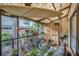 Cozy screened patio with colorful decor, potted plants, and unique surfboard ceiling at 240 Killarney Bay Ct # 4, Winter Park, FL 32789