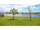 A serene backyard view of a tranquil community pond, complemented by verdant green space at 2612 Summer Clouds Way, Kissimmee, FL 34744
