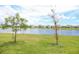 A scenic backyard view of a community pond, enhanced by lush greenery and neighborhood charm at 2612 Summer Clouds Way, Kissimmee, FL 34744