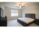 Cozy bedroom with a ceiling fan, bright window, and carpeted floor at 2612 Summer Clouds Way, Kissimmee, FL 34744