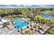 Expansive community pool area surrounded by palm trees and lounge chairs at 2612 Summer Clouds Way, Kissimmee, FL 34744
