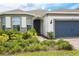 Home exterior with a brick walkway, lush landscaping, and a two-car garage at 2612 Summer Clouds Way, Kissimmee, FL 34744