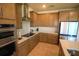 Well-lit kitchen featuring stainless steel appliances, wooden cabinetry, and neutral countertops at 2612 Summer Clouds Way, Kissimmee, FL 34744